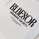 White t-shirt featuring a bold black graphic print on the front that reads 'BLUESOR MEMBERS' SOCIETY' with smaller text 'CREATED WITHOUT COMPROMISE Between Us'.